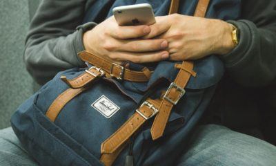 man using phone with backpack