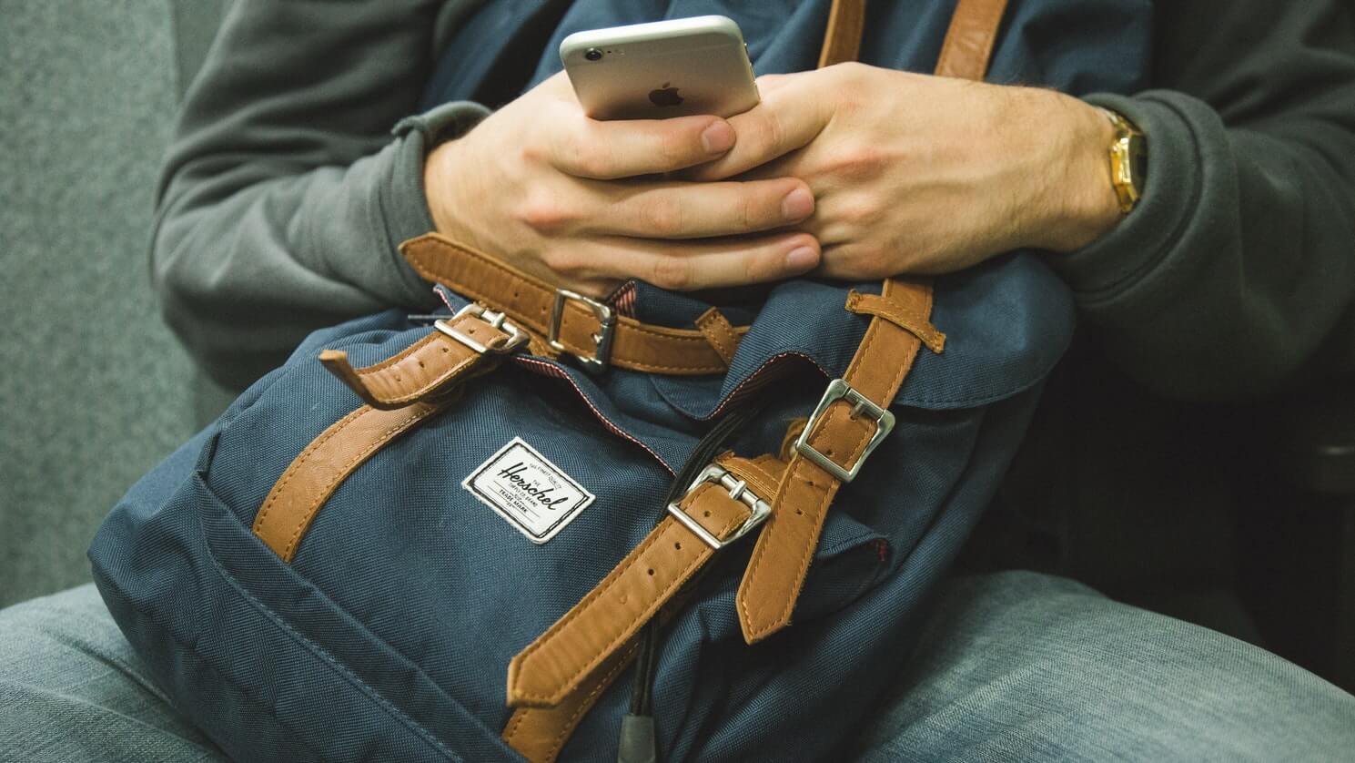 man using phone with backpack