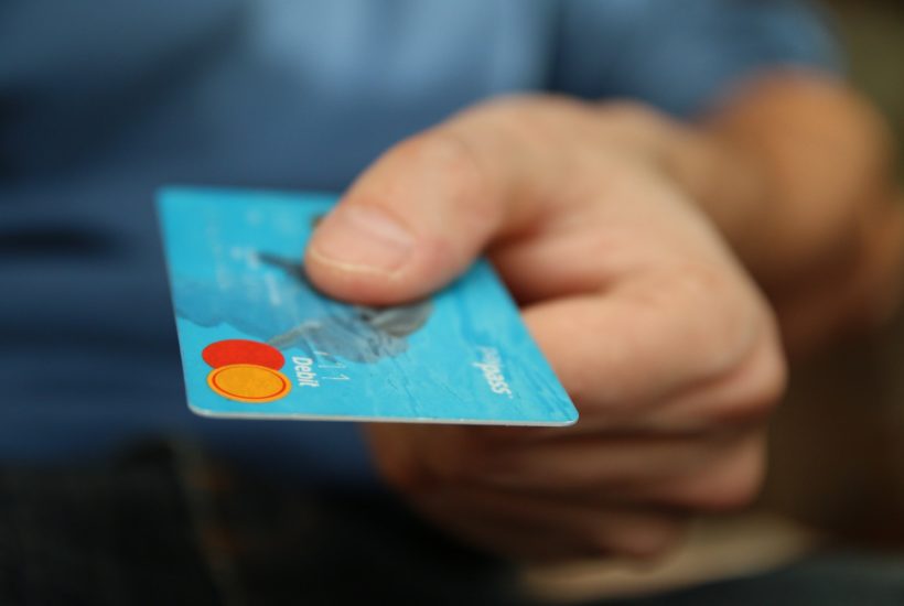 This picture show a man using a credit card.