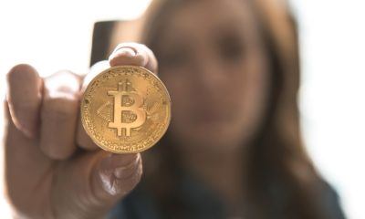 This picture show a woman holding a bitcoin.