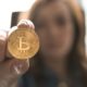 This picture show a woman holding a bitcoin.