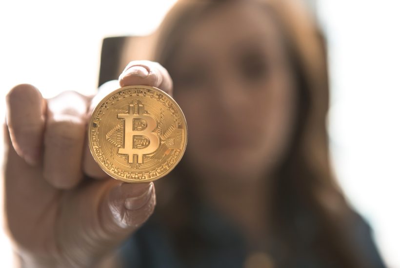 This picture show a woman holding a bitcoin.