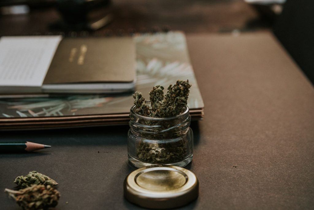 This picture show a bunch of marijuana in a small jar.