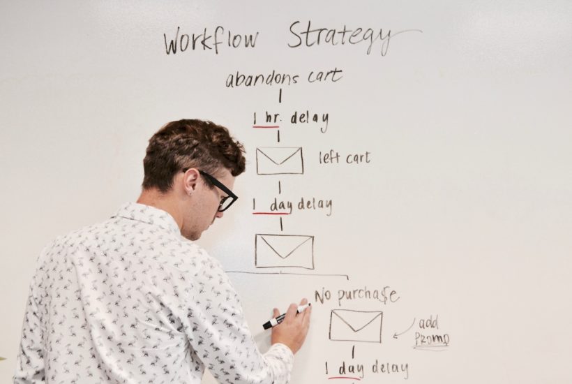 This picture show a man writing on a board.