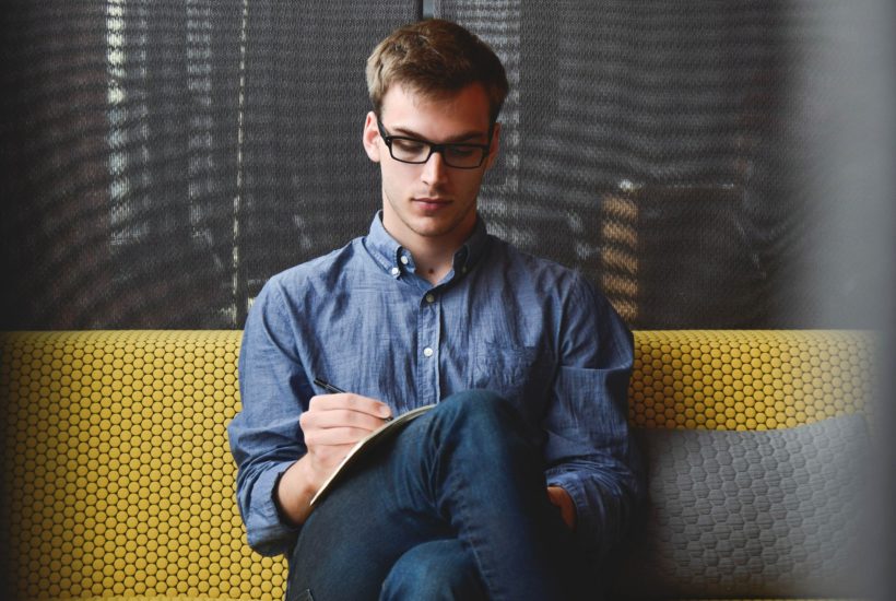 This picture show a guy writing things down, representing an employee of a french startups.