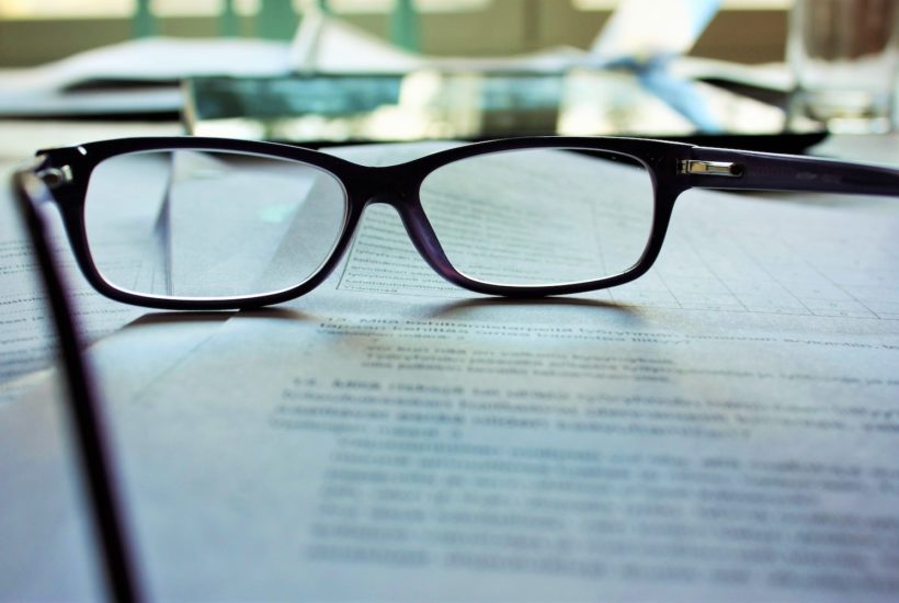 This picture show glasses on top of a book.