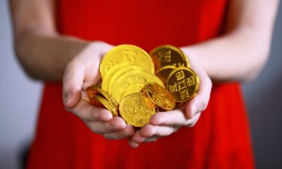 This picture show a woman holding some chinese coins.