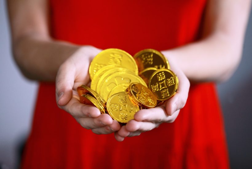 This picture show a woman holding some chinese coins.