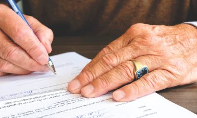This picture show a man signing some papers.