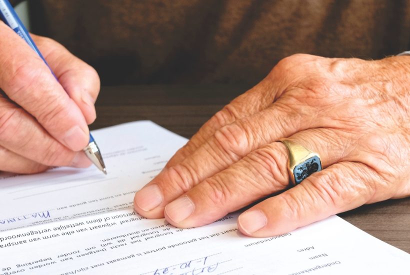 This picture show a man signing some papers.