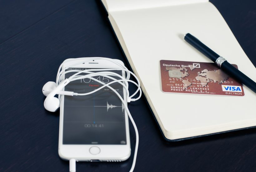 This picture show a smartphone beside a credit card, representing an e-wallet.