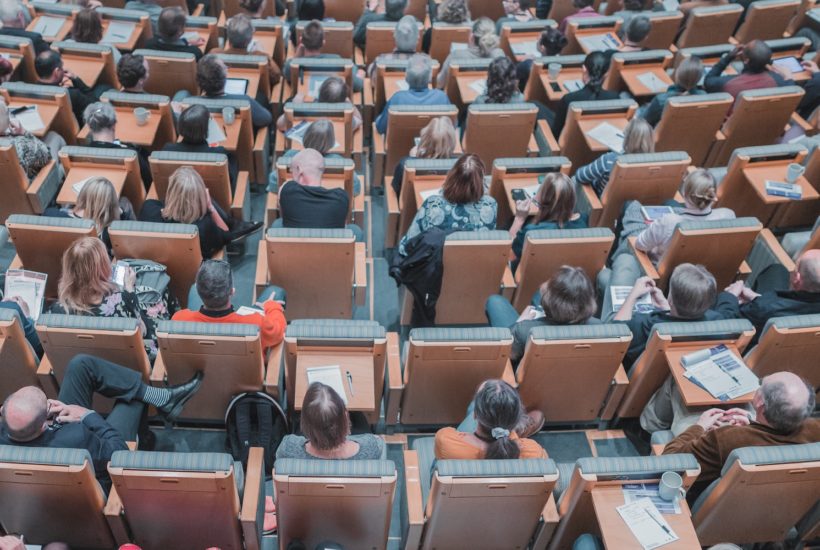 This picture show a group of people in a conference room.