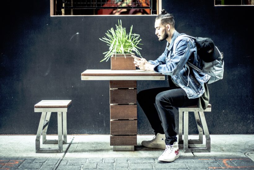 This picture show a millennial using his smartphone.