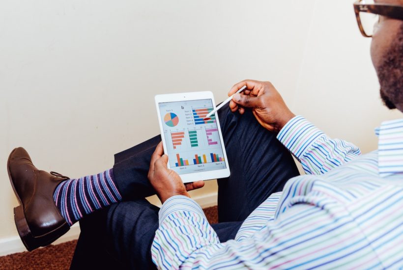 This picture shows a person looking at some fintech data on a tablet.