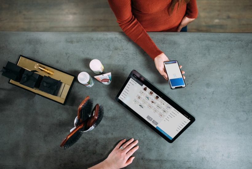 This picture show a person using her smartphone to pay for some services.