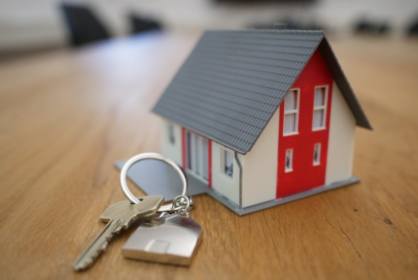 This picture shows a toy house with some keys beside it.