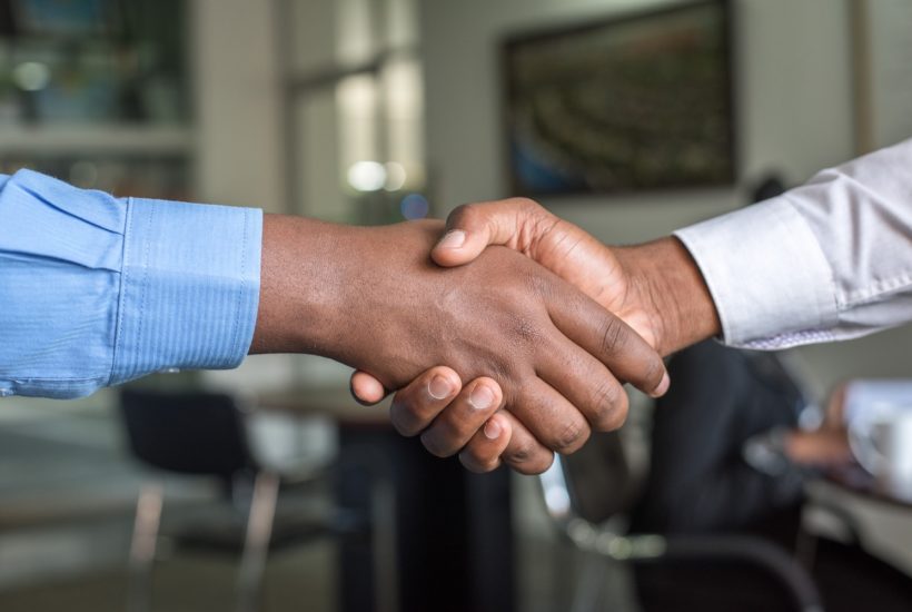 This picture show two person doing a handshake.