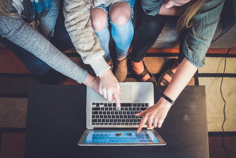 This picture show a group of people using a laptop.