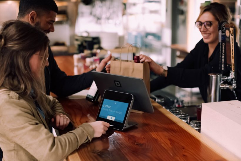 This picture show a woman paying with her smartphone.