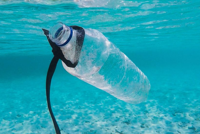 This picture show a plastic bottle in the middle of the ocean.