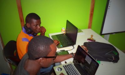 This picture shows two people using a laptop.