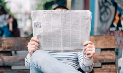 This picture shows a person holding a newspaper.