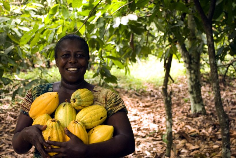 This picture show a woman holding some fruits.