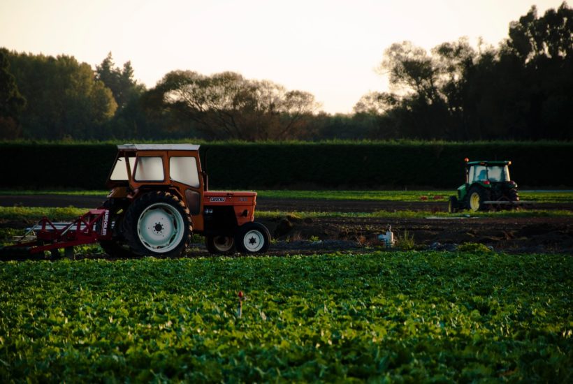 This picture show two tractors working on a farm.