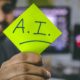 This picture shows a person holding an AI sign.