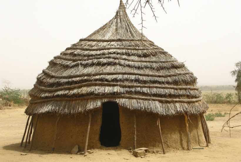 This picture show a hut in the middle of the desert.