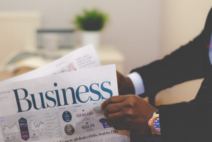 This picture show a person reading a business newspaper.