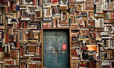 This picture show hundred of books and a door.