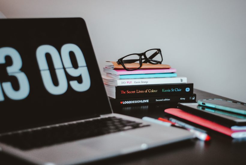 This picture show a macbook with a clock on it.