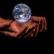 This picture show two hands holding a globe.
