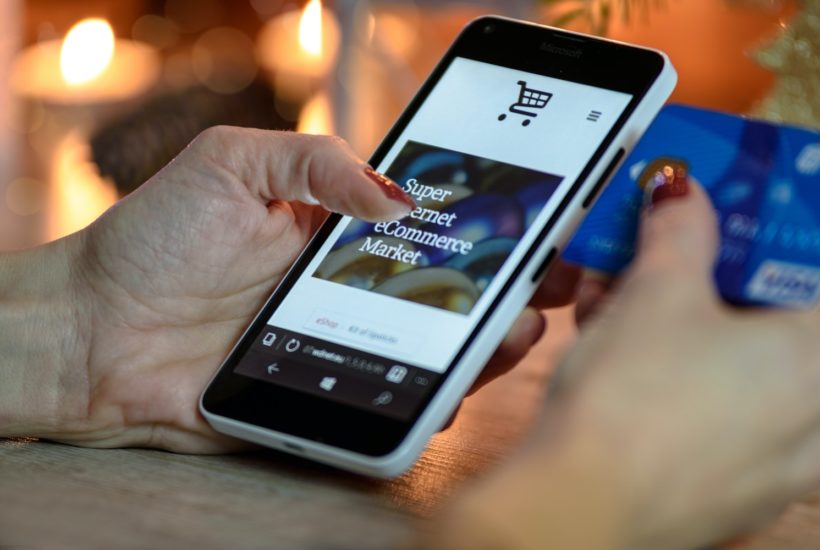 This picture show a person using his smartphone to shop online.