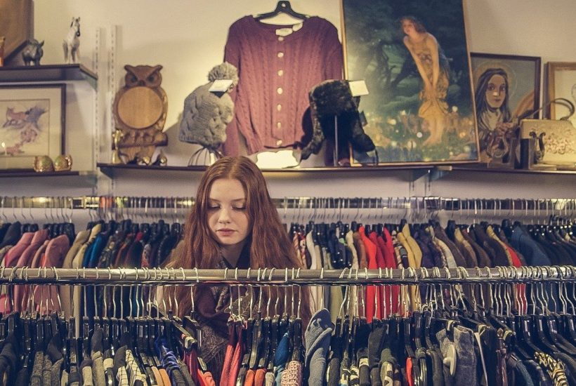 This picture show a girl looking at clothes.