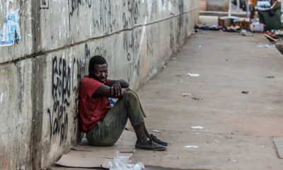 This picture show a person sitting on the street.
