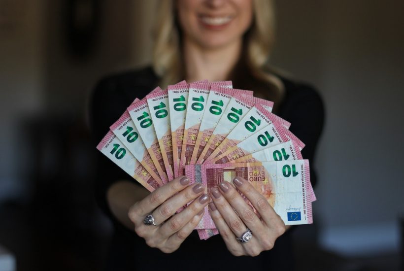 This picture show a woman holding some euro bills.