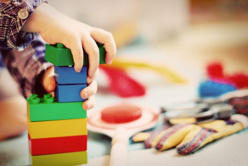 This picture show a boy playing with some legos.