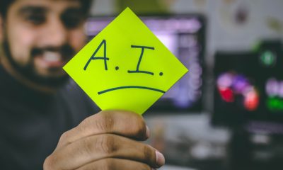 This picture show a persona holding a paper with the AI word written on it.
