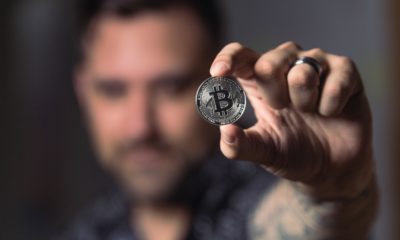 This picture show a person holding a Bitcoin.