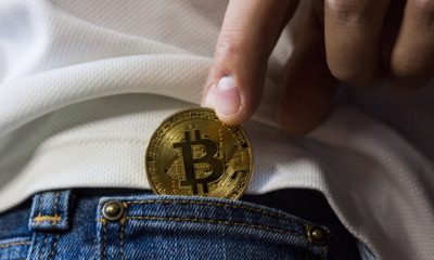 This picture show a persona putting a bitcoin in his pocket.
