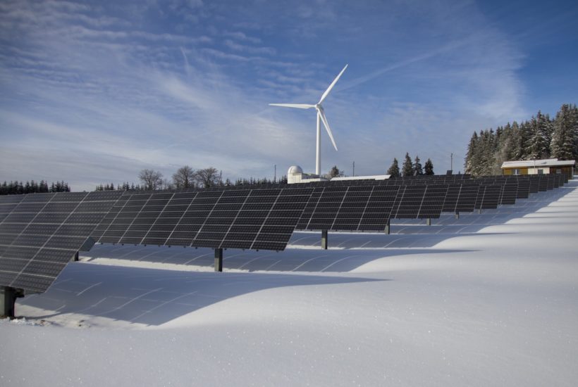 This picture show some solar panels and a wind turbine.