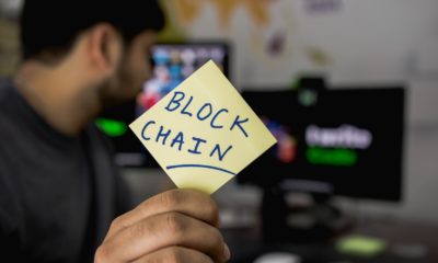 This picture show a person holding a blockchain sign.