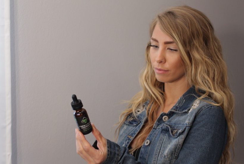 This picture show a person looking at a CBD oil.